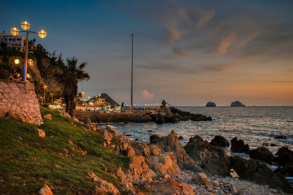 Charming house in Mazatlan, Mexico, illuminated by the soft light of dusk, offering a breathtaking view over the tranquil town and the ocean, epitomizing the peaceful and scenic retirement lifestyle by the sea