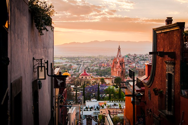 Breathtaking view from a hill during dusk of the colonial town of San Miguel de Allende, Mexico, with historic buildings bathed in the soft, golden light of the setting sun, capturing the timeless charm and serene beauty, perfect for a peaceful retirement